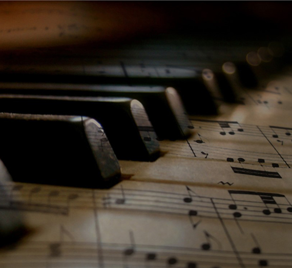 钢琴琴键被乐谱覆盖的图像