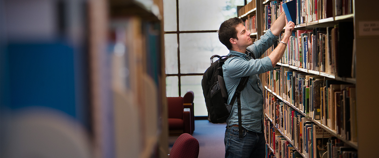 Student browsing library stacks
