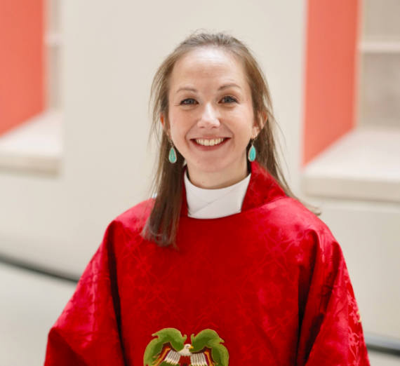 牧师Amanda Newell Large穿着红色宗教服装微笑着.