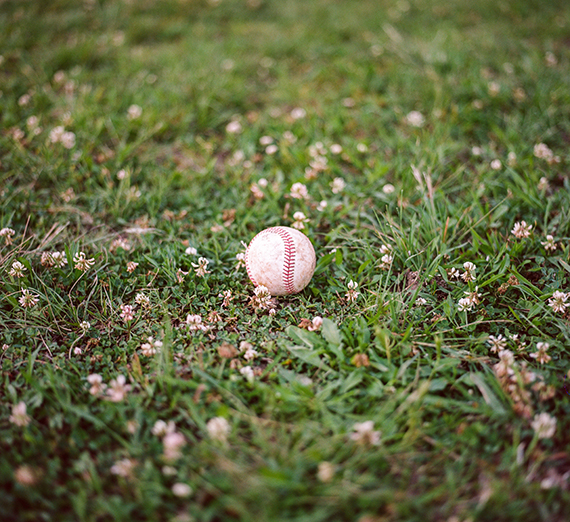 A baseball sitting in the grass 