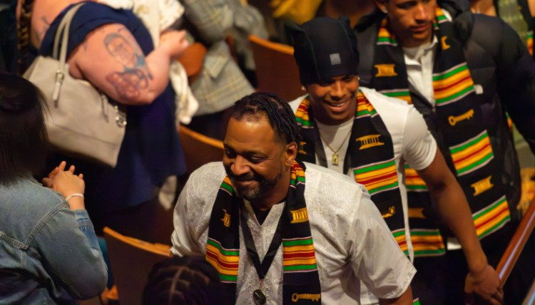 Graduates walk up the auditorium steps