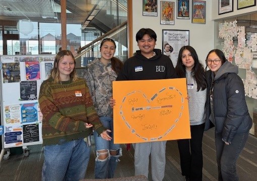 Students pose with their black out poetry poster