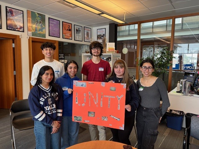 Students pose with their black out poetry poster