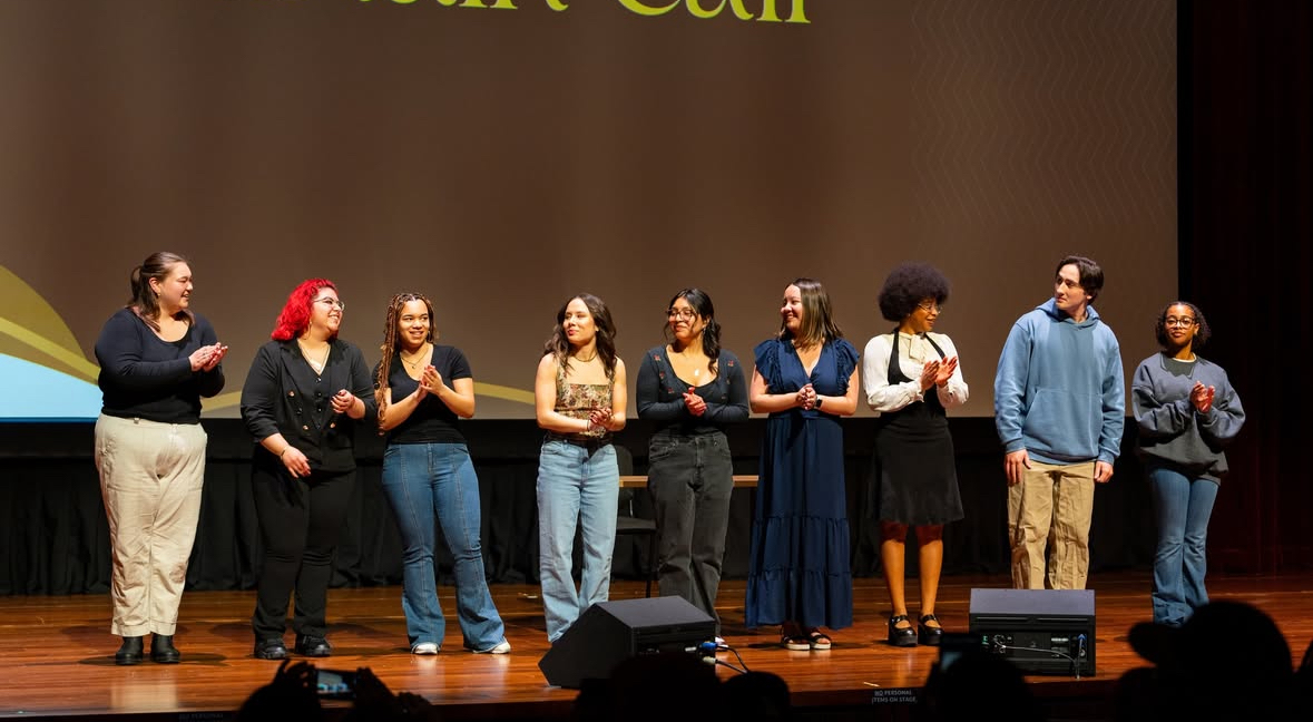 Students stand on stage