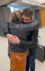 Mother and son hug at airport