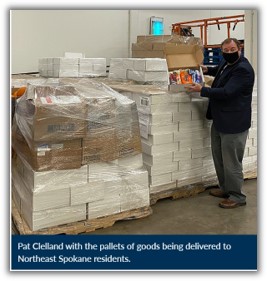 Pat Clelland with pallets of food and goods being delivered to Northeast Spokane residents