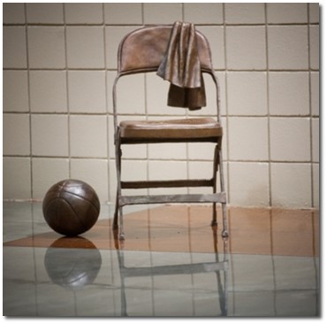 Bronze statue of a folding chair with a towel over the chairback and a basketball next to it