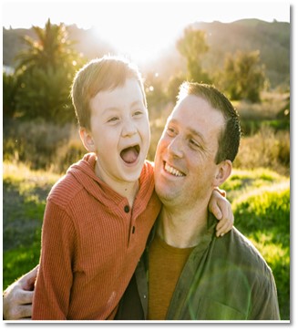 Father and son with arms around each other smiling. Caleb and Evander Webster
