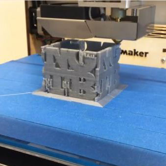 3D printer printing a Next Gen Tech Bar logo cube