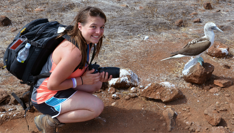 Study Abroad student posing with a blue footed booby