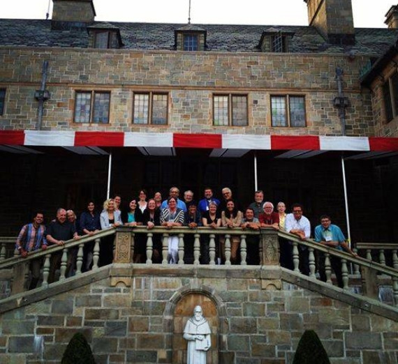 A group of AJCU Communications Conference attendees photopgraphed outside on a building stairway.