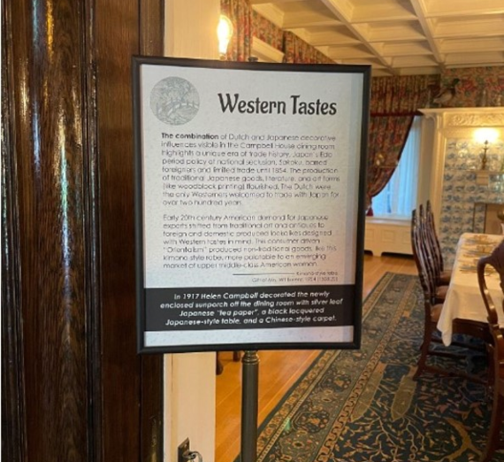 Dining room at the Campbell House with historical artifacts displayed and sign describing the exhibit. 