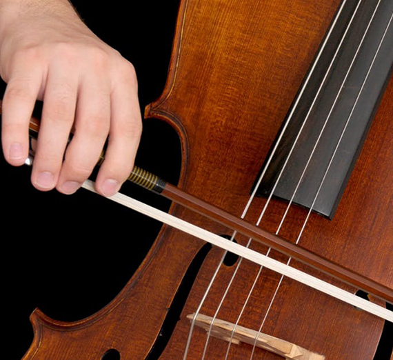 Close up image of a hand bowing a Cello