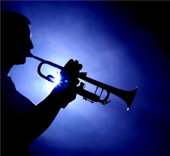 Silhouette image of a man playing trumpet