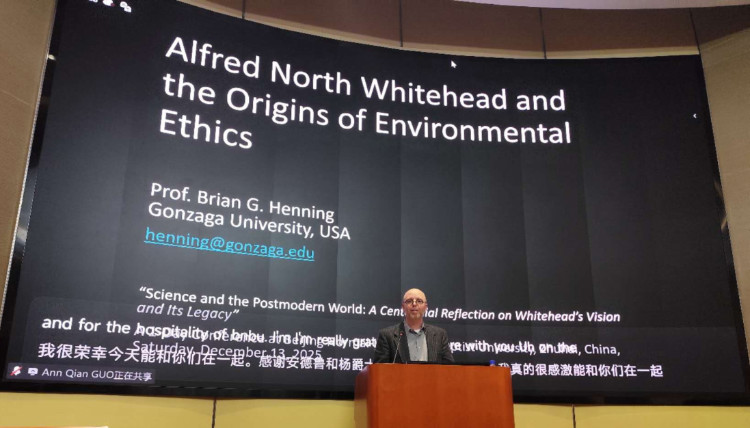 Conference presentation in Zhuhai, China featuring a large screen displaying the title ‘Alfred North Whitehead and the Origins of Environmental Ethics’ by a Gonzaga University philosophy professor. The slide includes contact information and references to the event ‘Science and the Postmodern World: A Centennial Reflection on Whitehead’s Vision and Its Legacy,’ held December 2025.