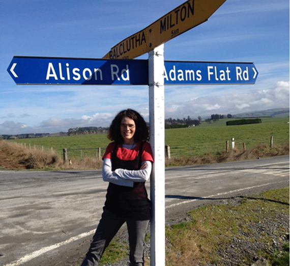 Alison McCulloch, Gonzaga Philosophy graduate, stands in front of a street sign bearing her first name.