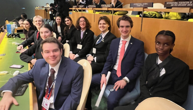 Gonzaga University Model United Nations delegates seated inside the United Nations Headquarters during the NMUN 2025 conference. The photo shows rows of desks with country nameplates, official conference badges, and participants preparing for committee sessions.