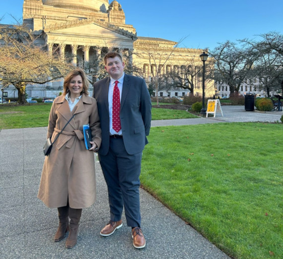 President Katia Passerini and student Jack Korshak of Gonzaga University standing in front of the Washington State capitol building in Olympia, Washington.