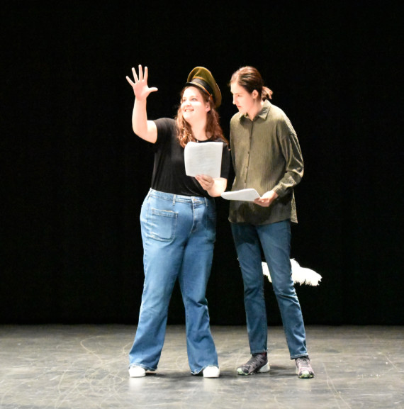 Two actors performing a scene on stage. 