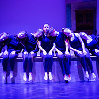 Dance troop lineup on purple background.