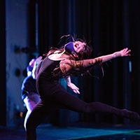 Dancer in movement on stage.