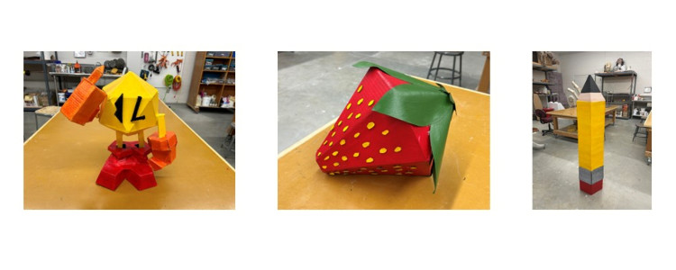 3D sculpture of a little yellow character, a strawberry and a pencil.