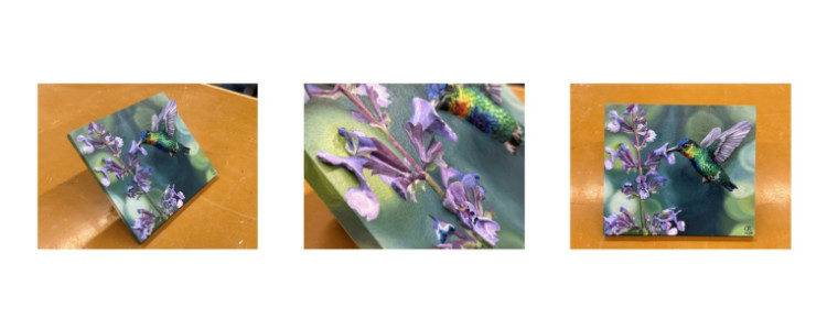 3D sculpture of a painting of lilacs with a hummingbird which is standing off the canvas. 