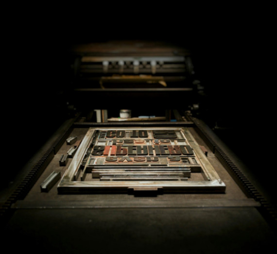 A type setting letter press in a dark room. 