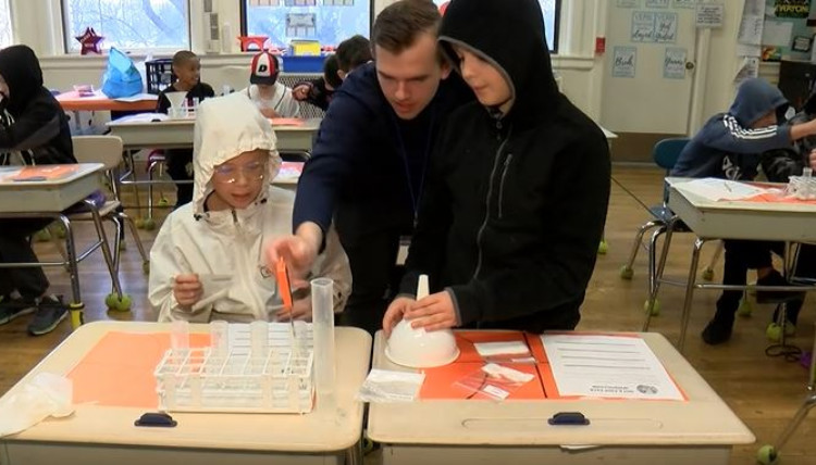 Gonzaga Student working on a science activitiy with two children. 