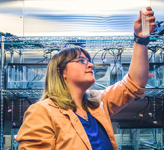 research student holding a sample up to the light
