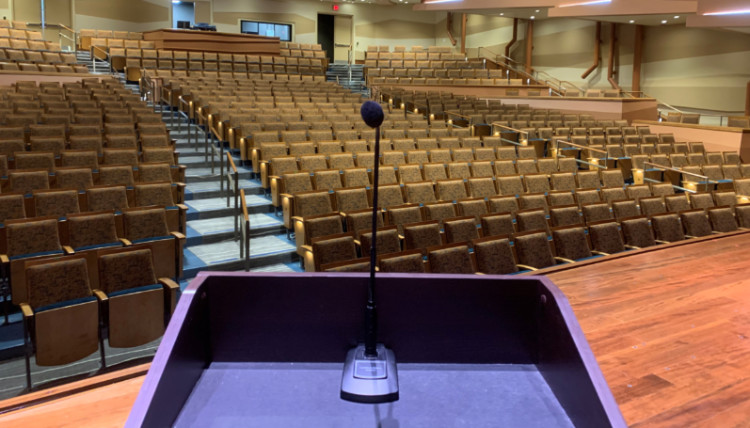 Stage of the Myrtle Woldson Performing Arts Center with curtain closed, podium set up. 