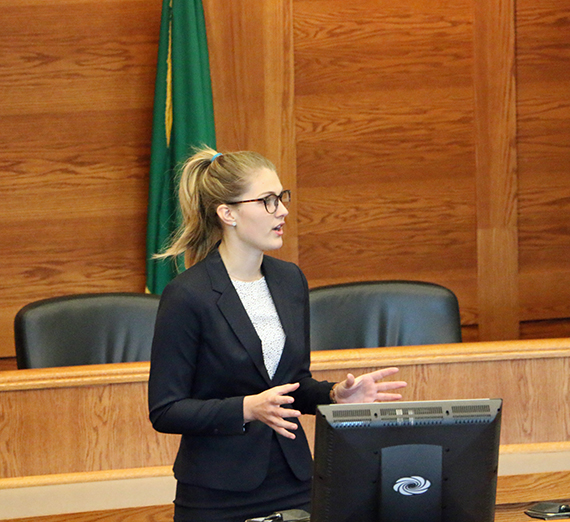 Maggie Kruzner stands in front of a mock trial court room.