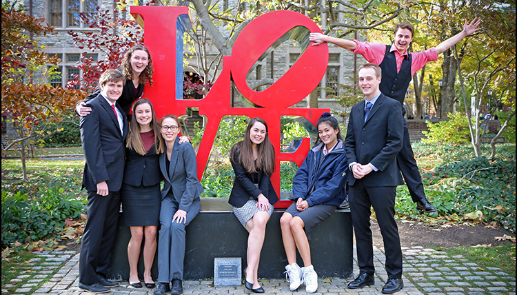 Gonzaga Mock Trial students gathered around a public art piece with letters that spell the word love.