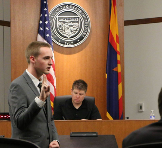 Student taking oath in court room with Arizona crest in background. 