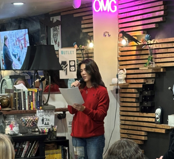 A person standing with a microphone reading from a paper.