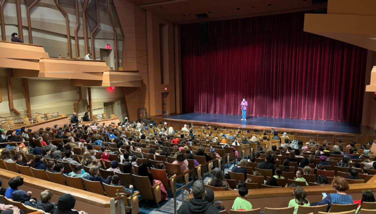 An audience at the Myrtle Woldson Center listening to a presenter on stage