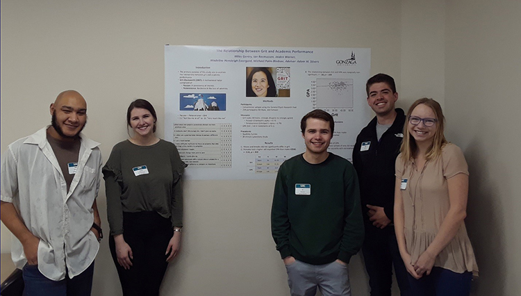 Students standing with a research poster.