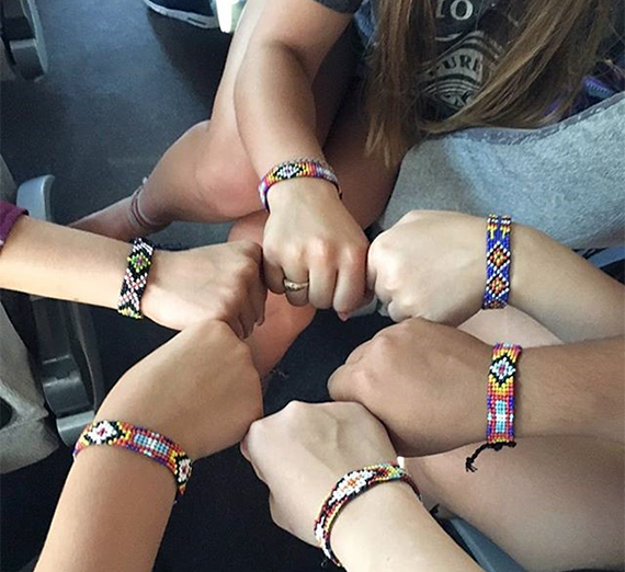 Hands arranged in a circle with bracelets made at summer camp