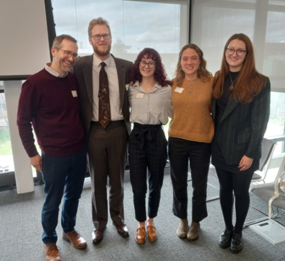 A group photo of a faculty member and four students