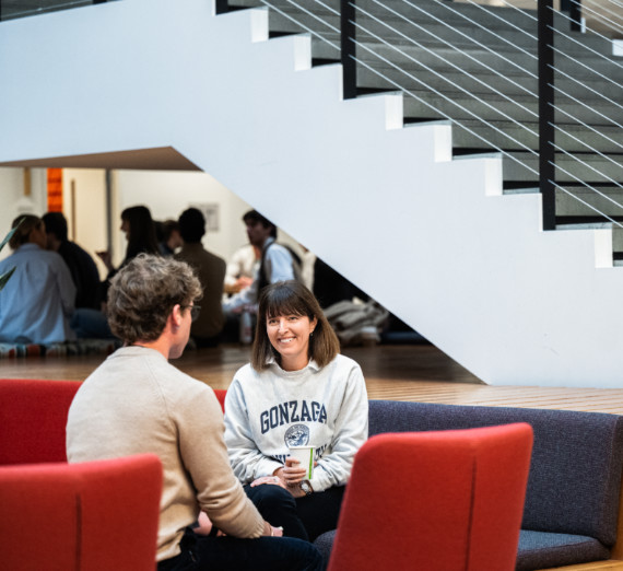 Two people chatting, one wearing a Gonzaga sweatshirt. 