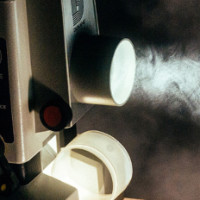 Vintage projector close up of the front playing a film