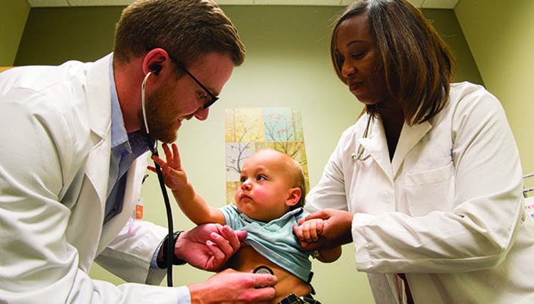 Second-year medical student Kenley Unruh with pediatric patient and instructor Dr. Cicely White in Spokane.