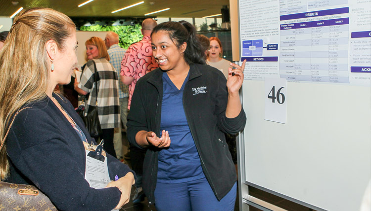 A UW medical student shares her research with a visitor
