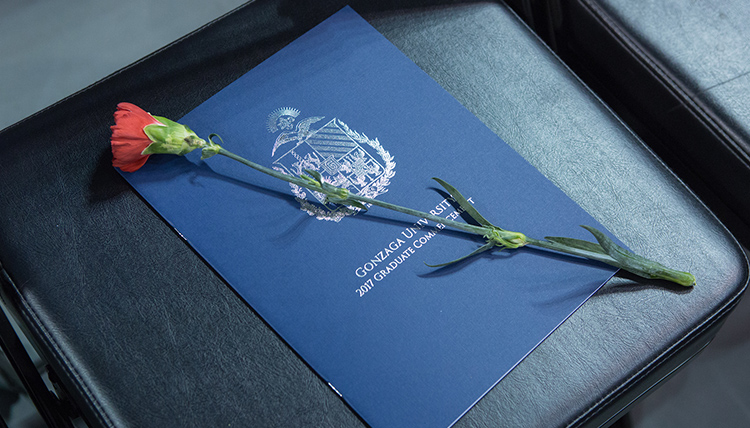 A program and rose in a chair at the 2017 Commencement ceremony