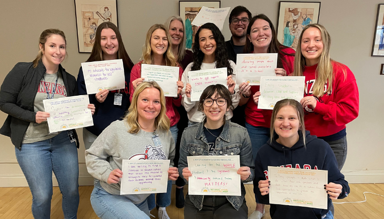 School Counseling students hold up pieces of paper with their hopes written on them