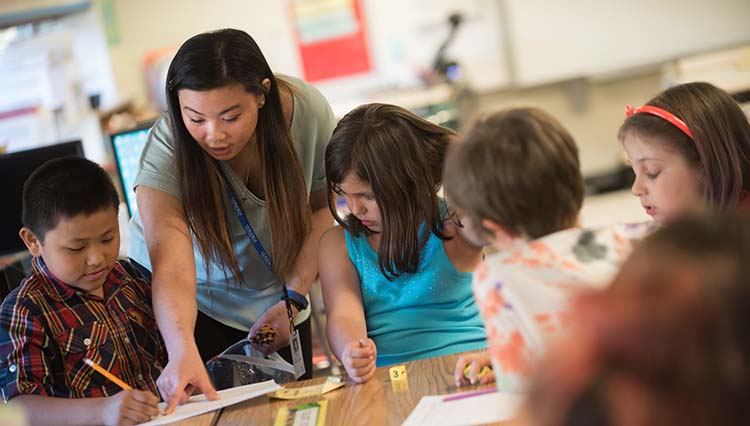 Teacher and students at a table.