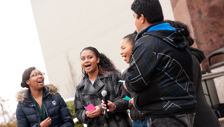 A group of students singing outdoors. 