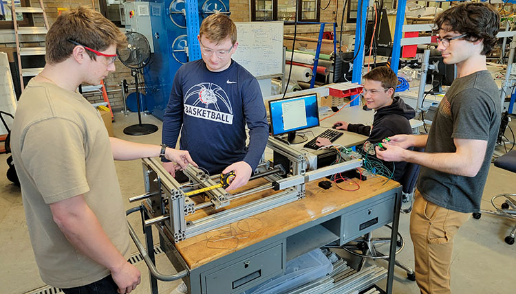 mechanical and electrical engineers work on machine