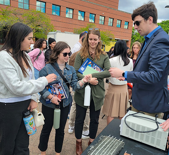 visitors hold a prototype created by a mechanical engineering team