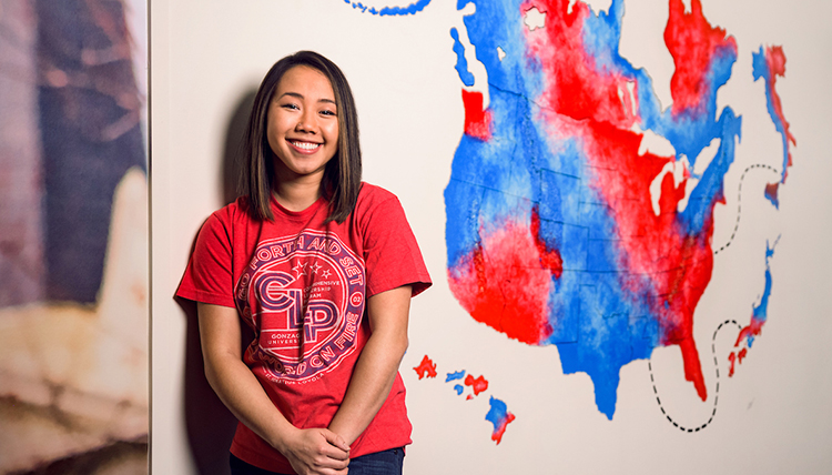 Gonzaga alumna stands in front of a Zag Nation mural